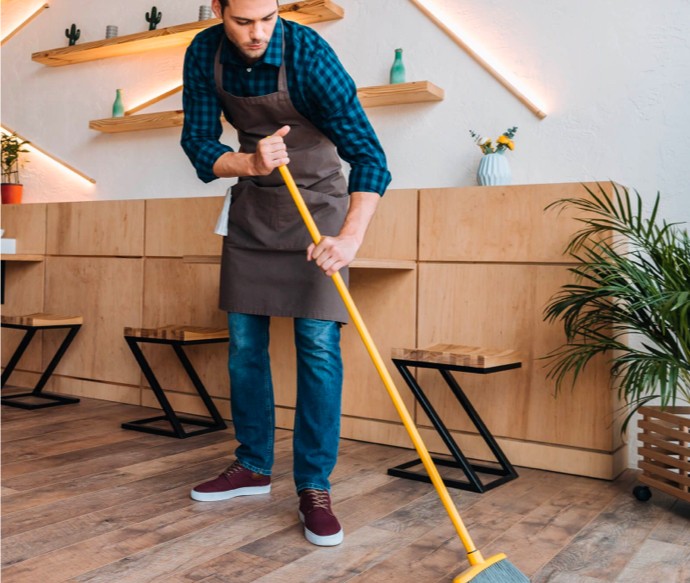 Man sweeping hardwood flooring | Nemeth Family Interiors